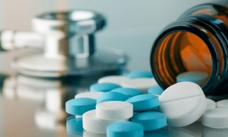 Blue and white pills are spilled near a stethoscope. assisted suicide, assisted death, euthanasia, euthanized