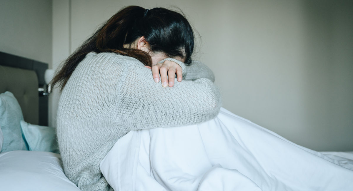 Image of woman crying with her head down. loss, abortion, Japan, miscarriage, abortion pill